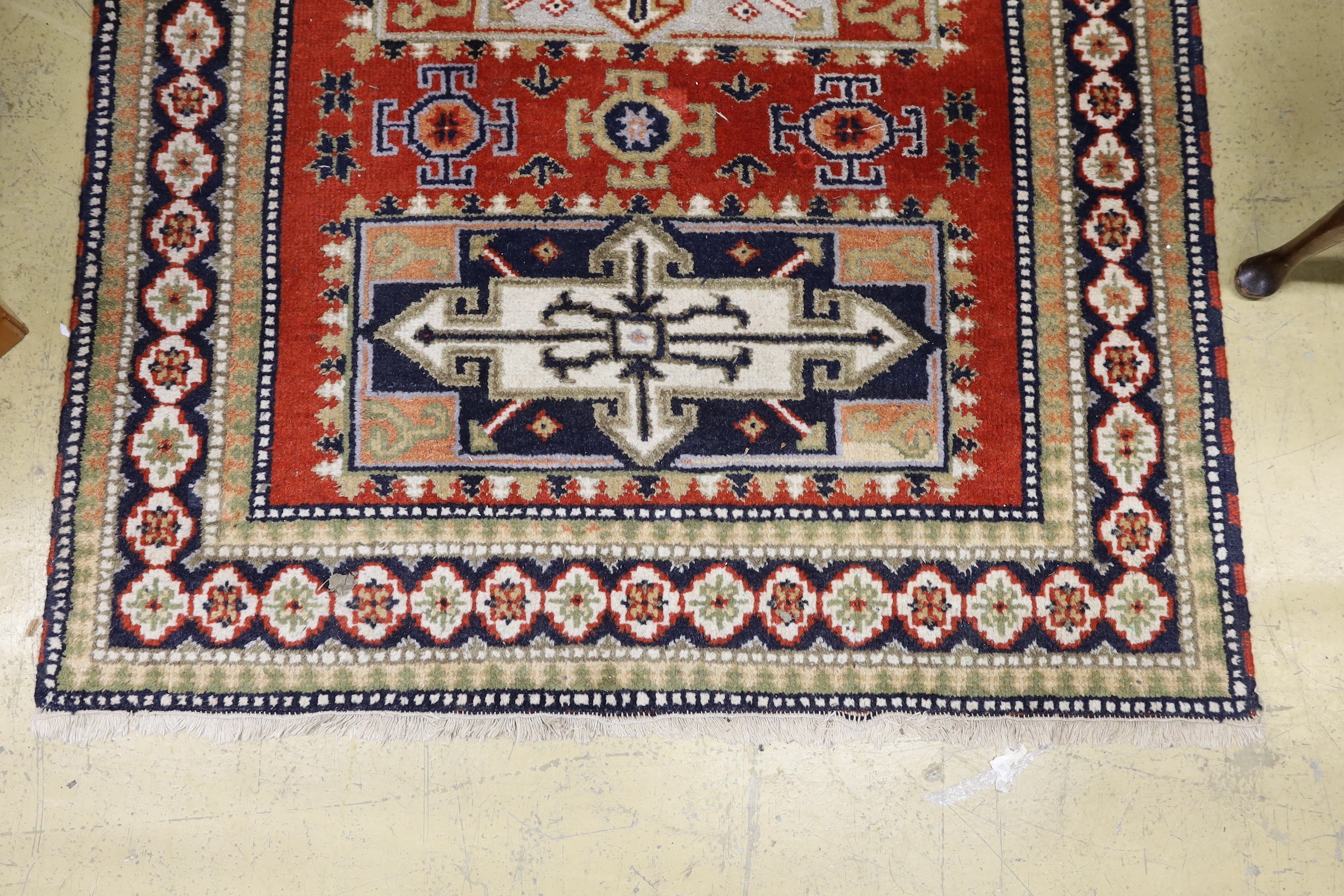 A Caucasian style brick red ground rug, 180 x 128cm